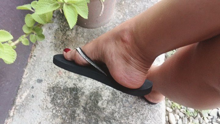 Goddess Foot Fetish - Pronounced arches in flip-flops hanging from a lady's feet (3)